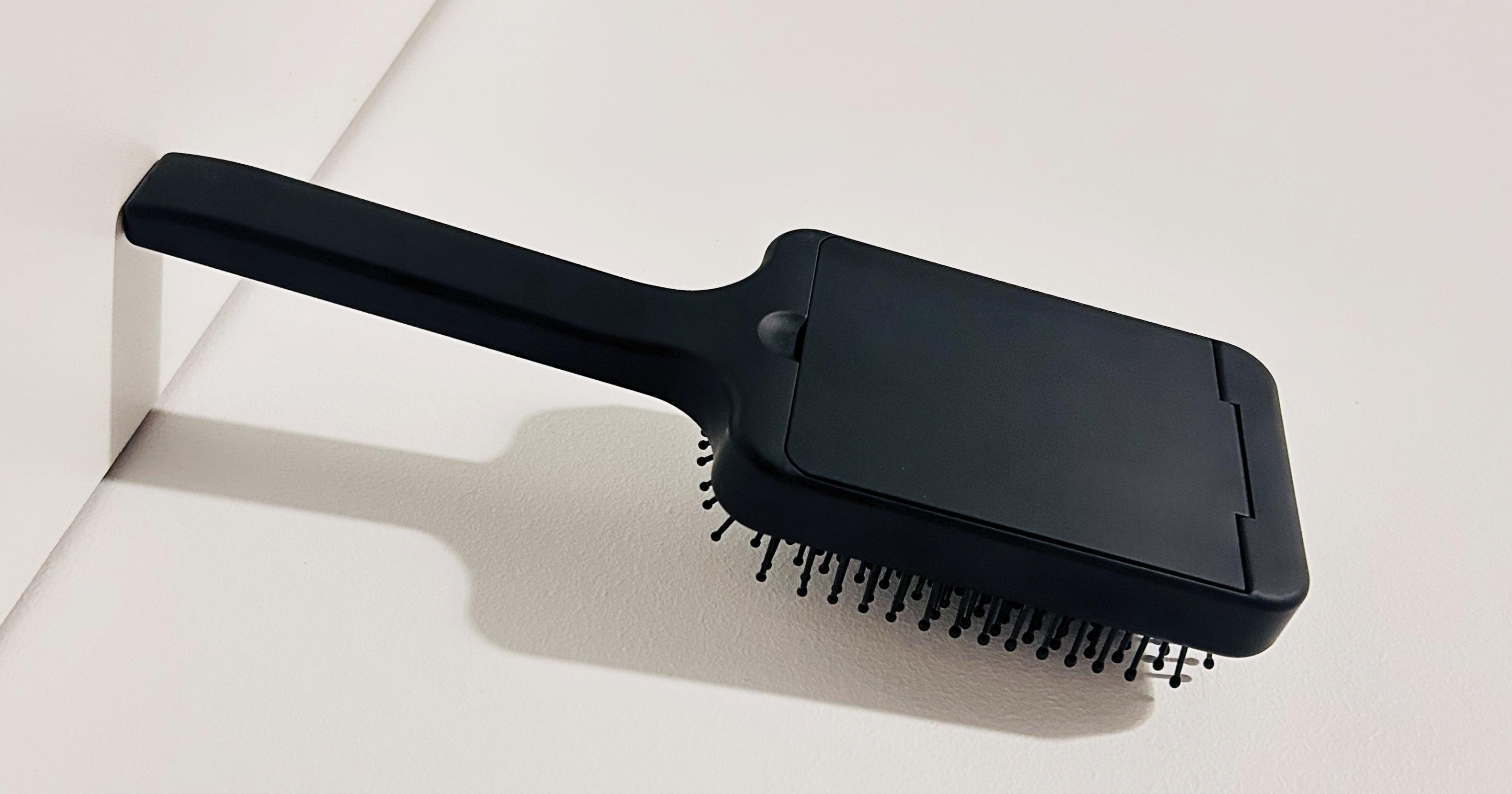 Black hairbrush with bristle head on a white background